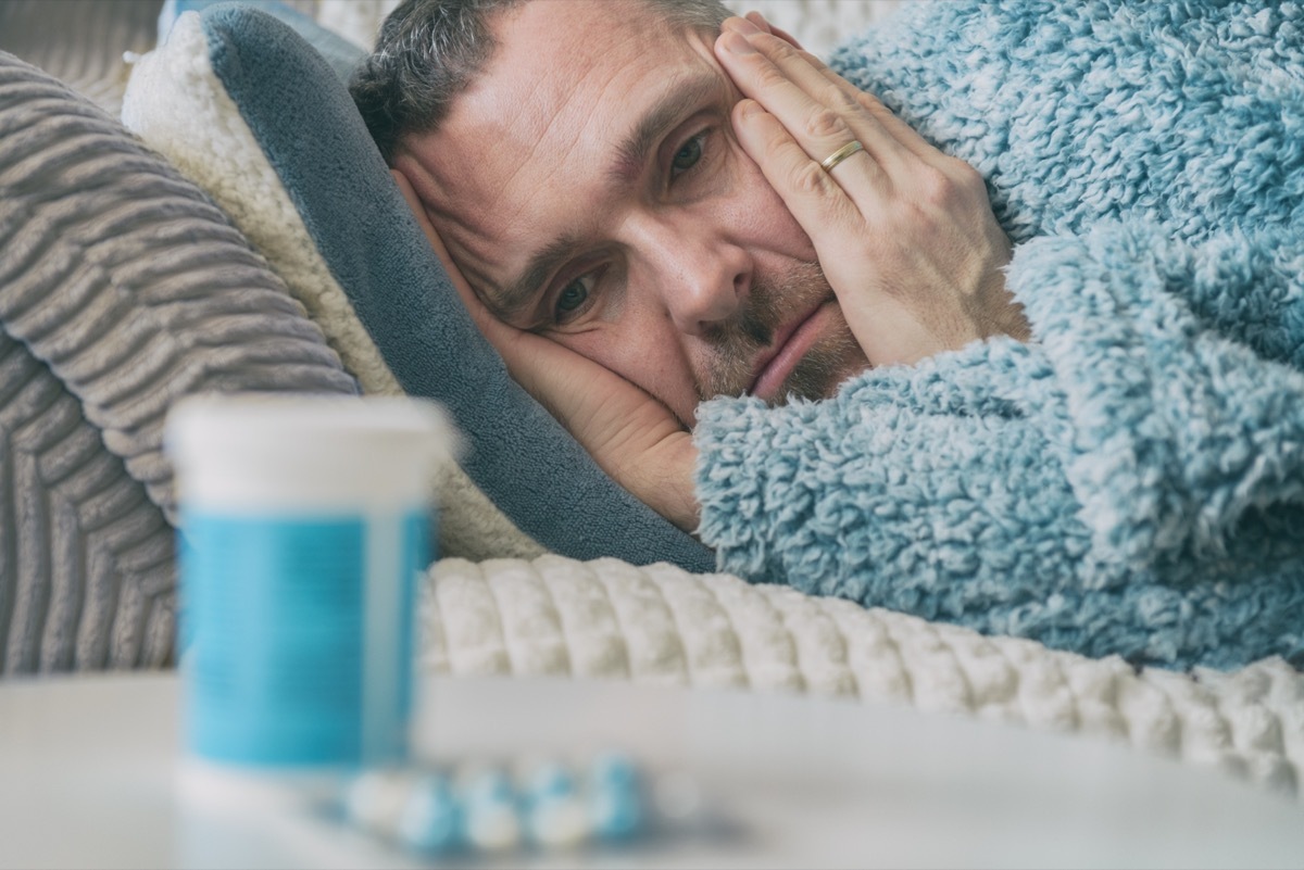 Man In Bed Next to Antidepressants