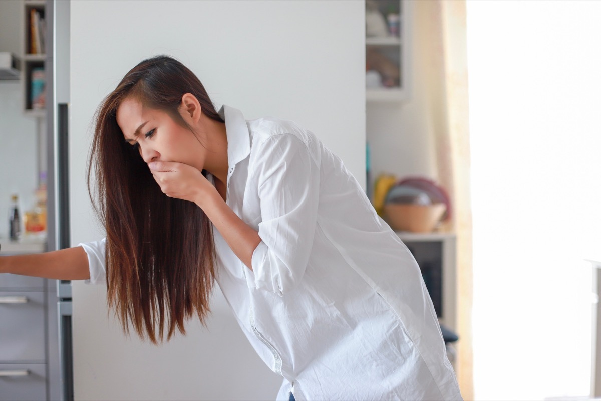 young asian woman with nausea covering her mouth