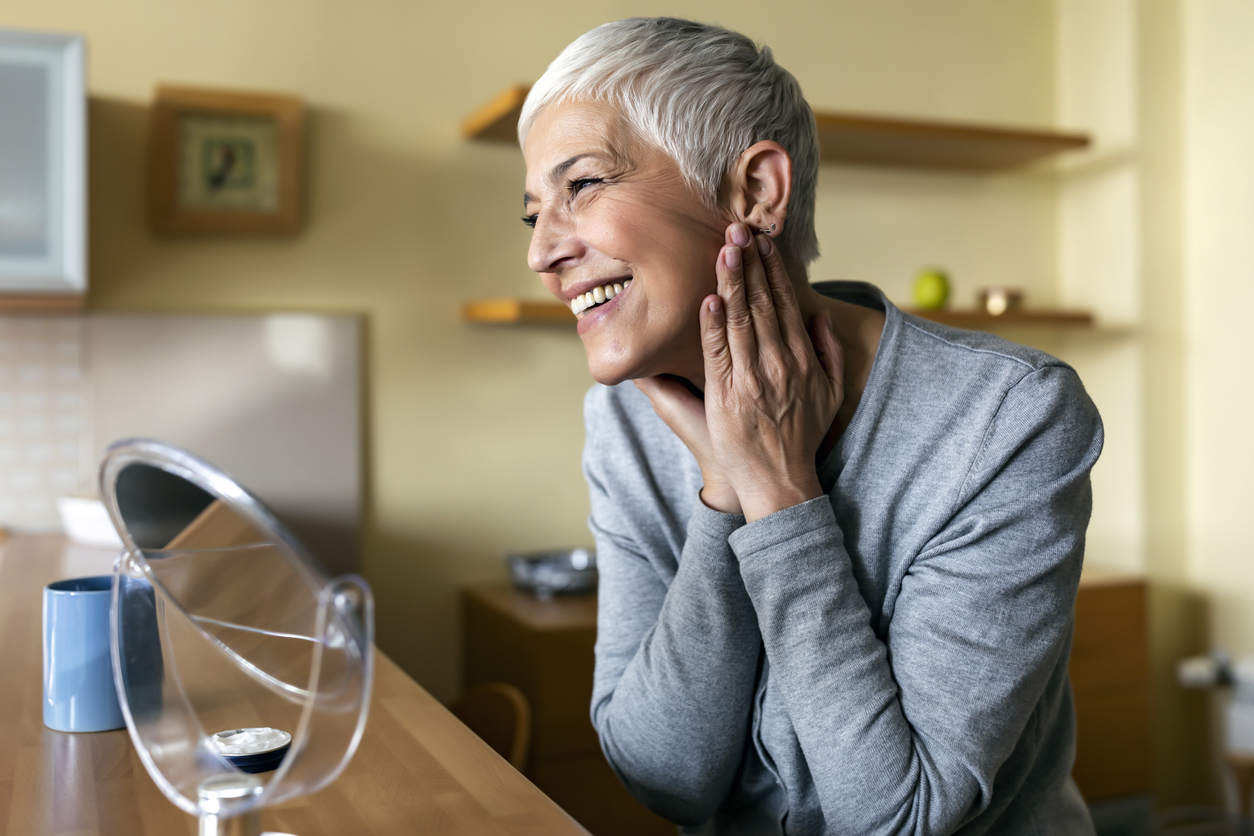 Older woman looking at her reflection in a mirror.