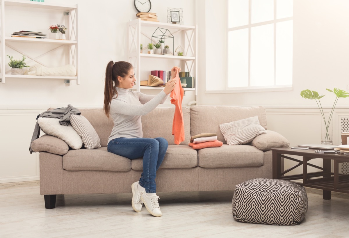 Girl folding laundry on couch