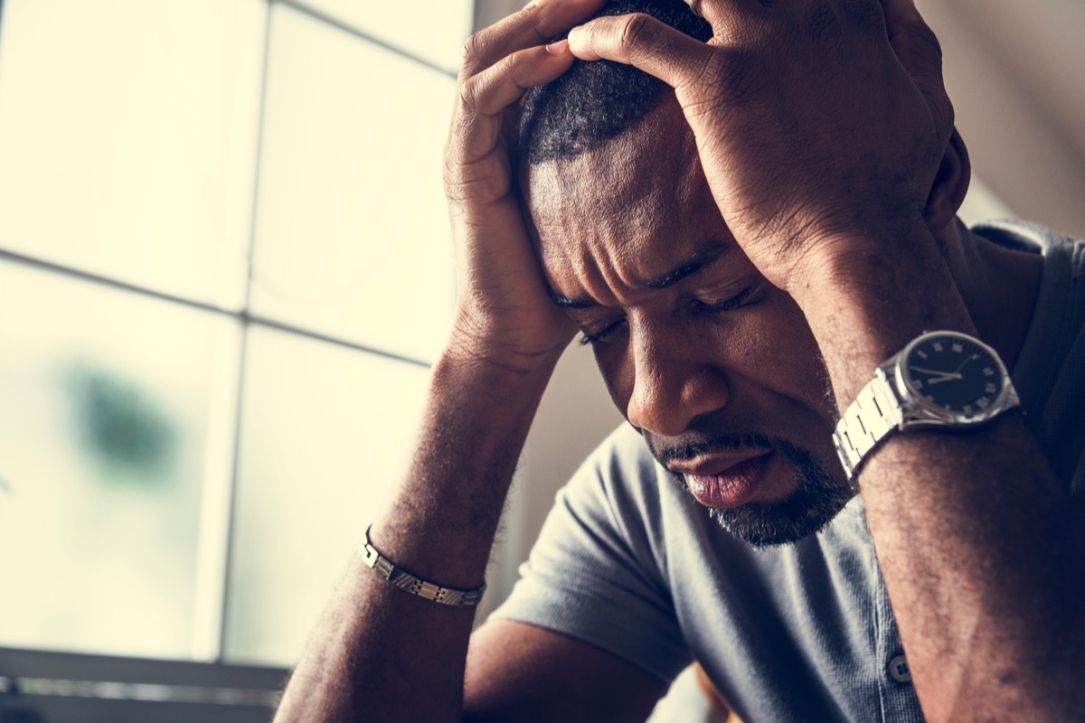 man holding his head in his hands