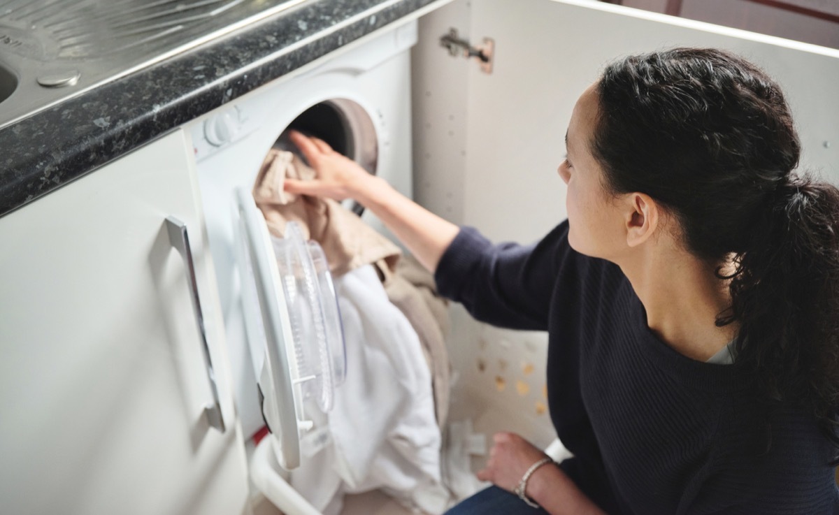 Shot of a woman doing laundry at home.