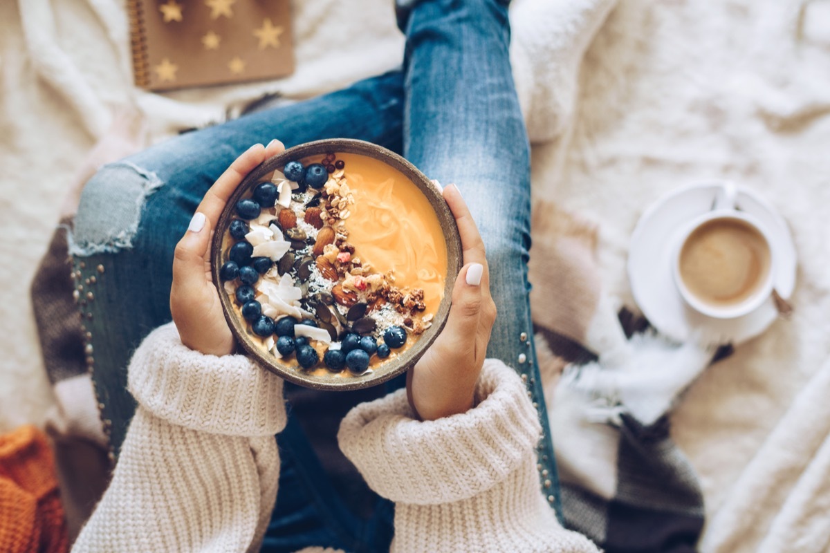 Pumpkin pie smoothie bowl topped with berries, granola, and coconut flakes