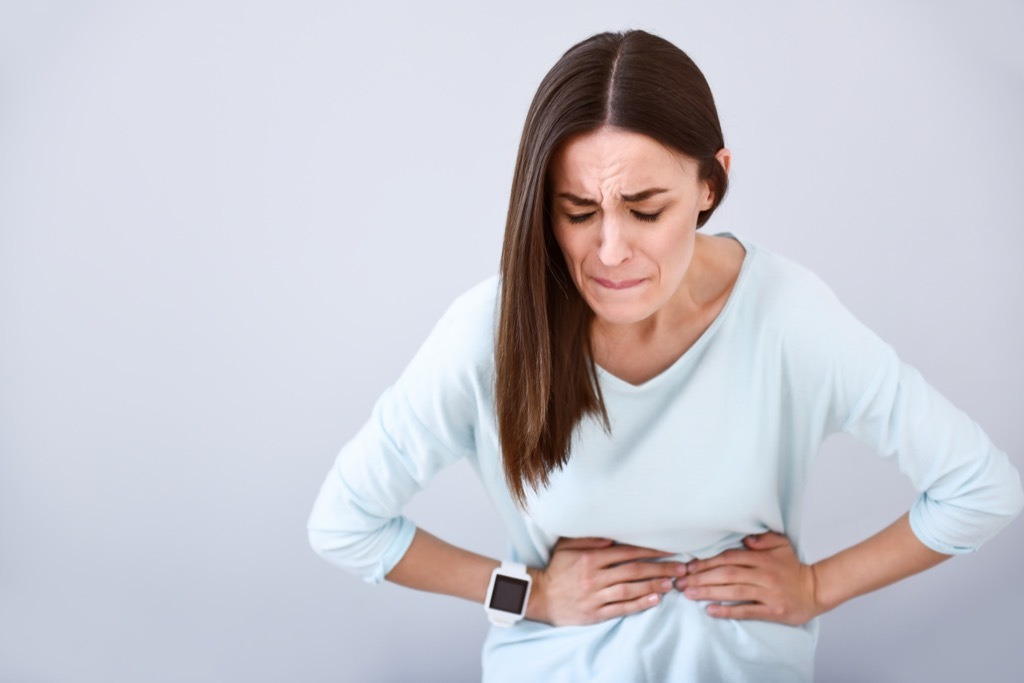 woman holding her stomach in pain, ways your body changes after 40