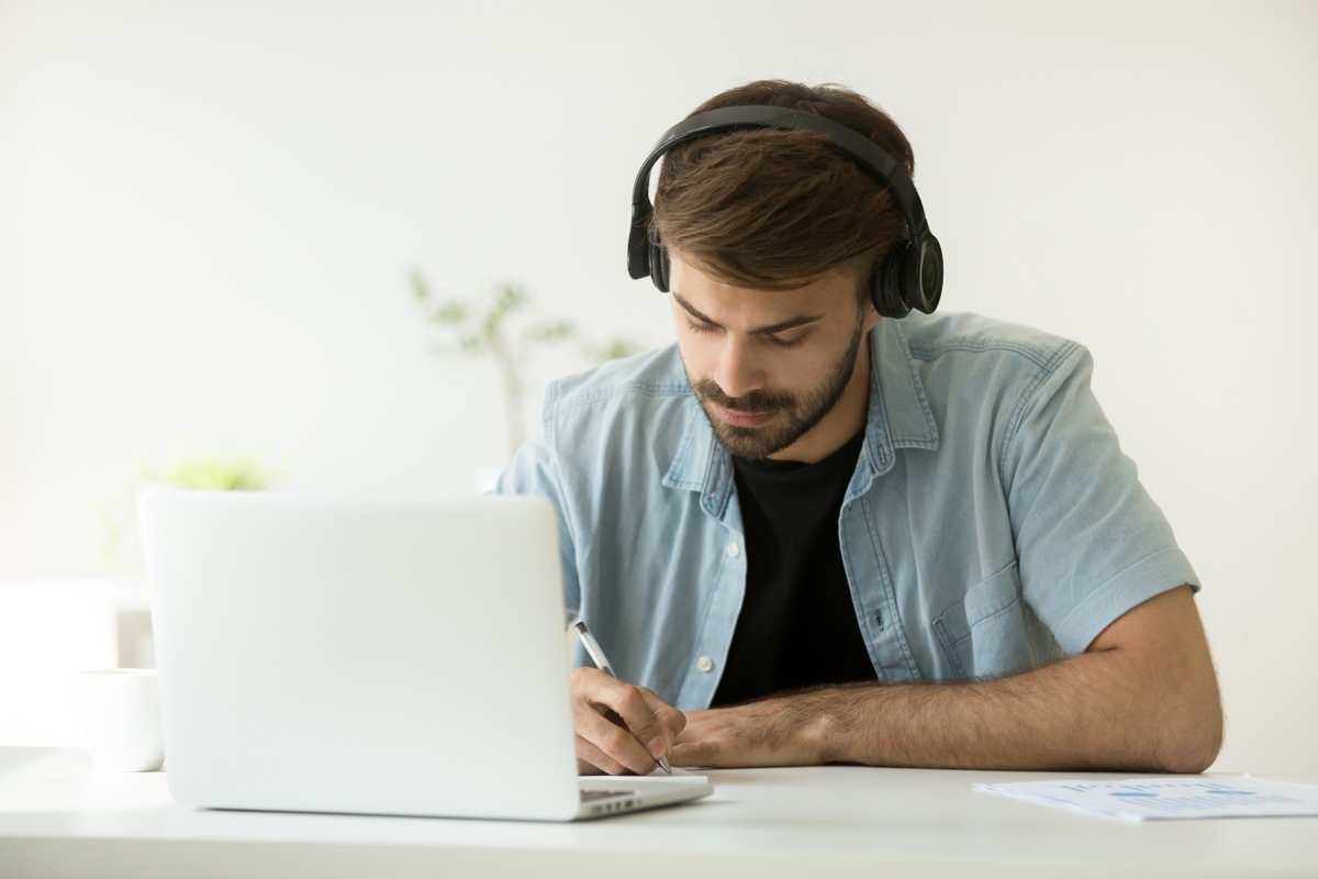 College Student Watching a Lecture on His Laptop With headphones ways college is different