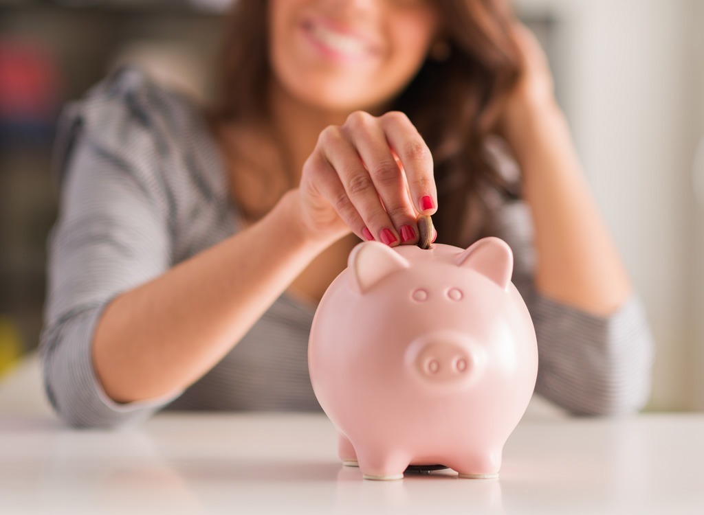 woman putting money into piggy bank