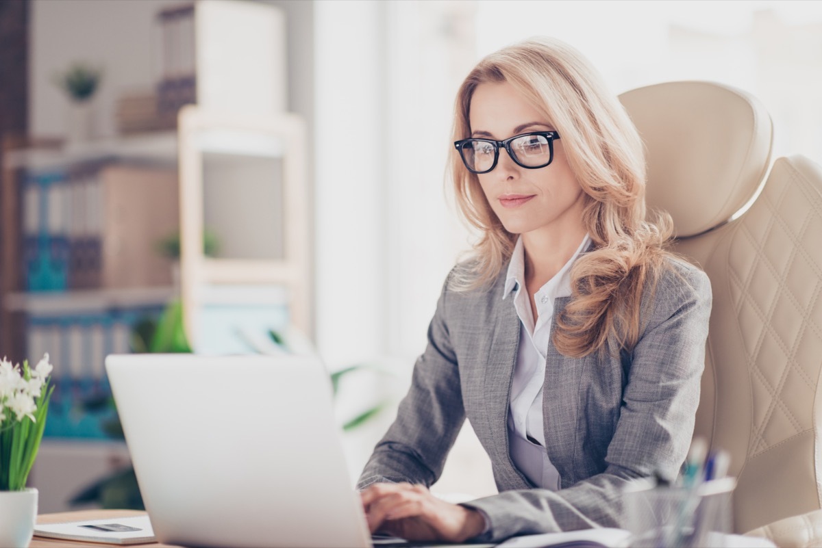 woman sitting at a desk in front of a laptop, ways to feel amazing