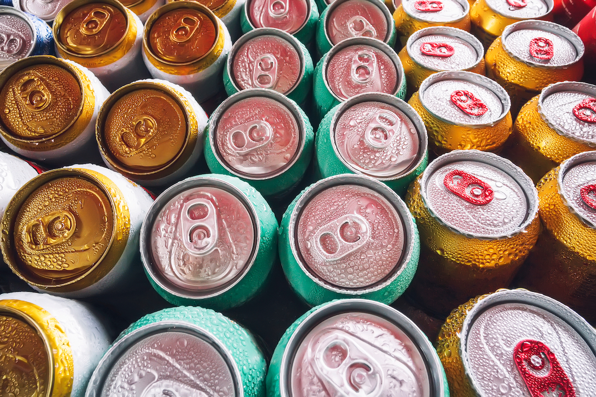 Metal cans of seltzer with ice cubes in mini refrigerator