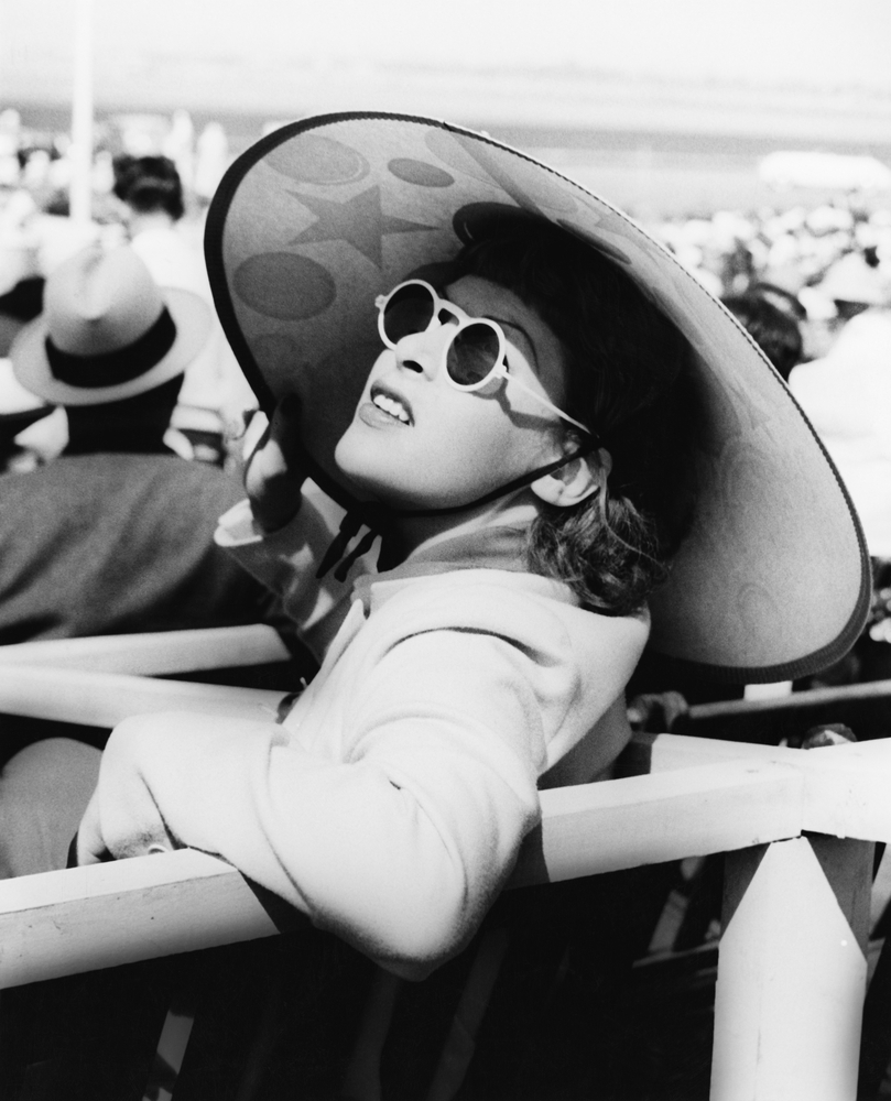 Woman in a big sun hat and sun glasses in 1940s