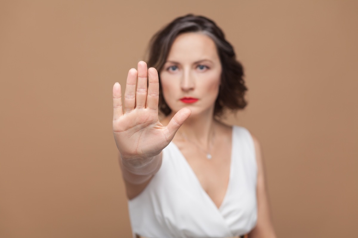 white woman putting up her hand to say stop