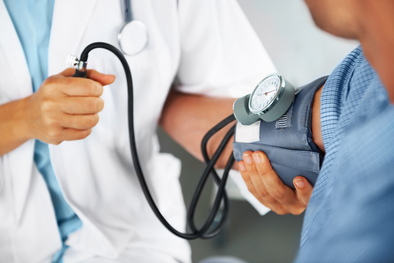 A doctor listening to his patient's heartbeat with a stethoscope.