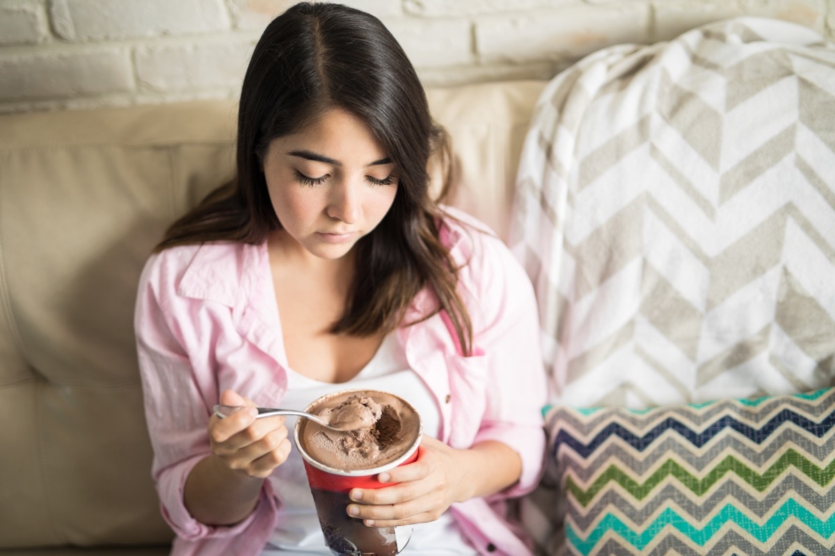 sad woman eatnig ice cream in bed