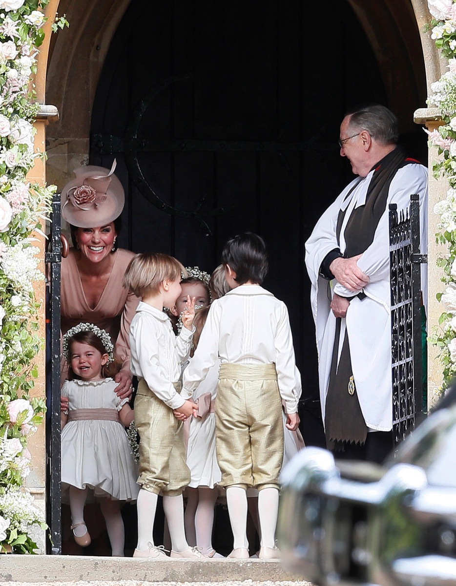 The Duchess of Cambridge, left, stands with her daughter Princess Charlotte, bottom left, as they arrive for the wedding of her sister Pippa Middleton to millionaire groom James Matthews