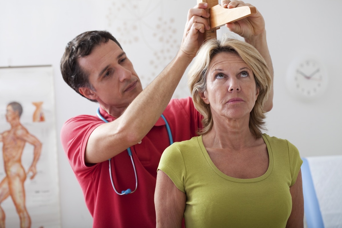 a doctor measuring a woman's height