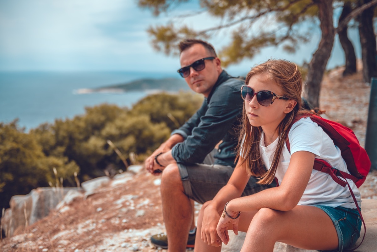 father and daughter sitting on rocks after hiking with each other