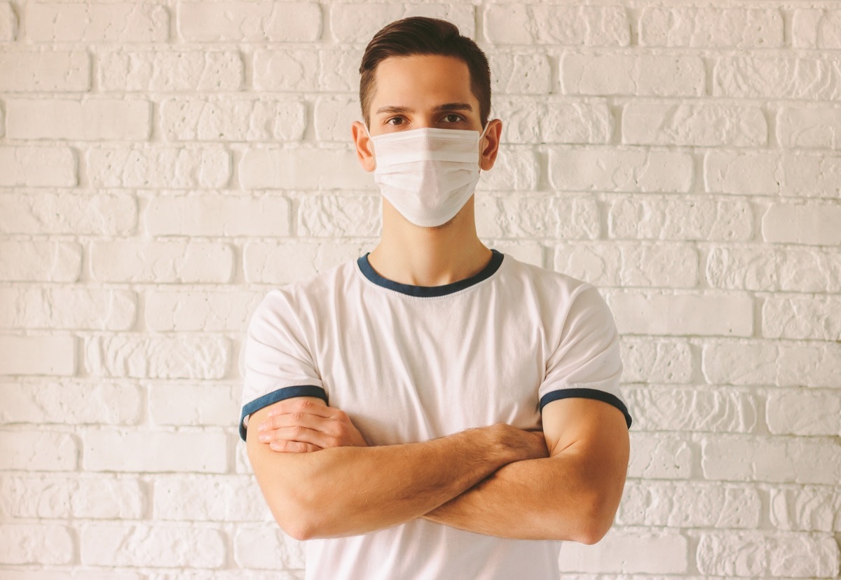 Portrait young confident man wearing face mask for protection against chinese coronavirus COVID-19