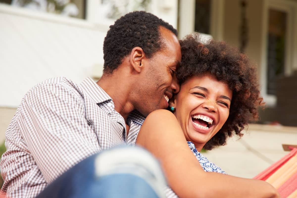 black couple laughing on couch